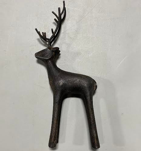 The Cast Iron Deer features a dark brown, minimalist design with prominent antlers, making it a perfect rustic décor accent for any home when displayed on a light gray surface.