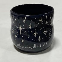 Load image into Gallery viewer, The Black Starry Planter, a dark blue ceramic piece with white stars and the phrase &quot;All is calm, all is bright,&quot; is perfect for holiday floral arrangements and looks elegant on any light-colored surface.