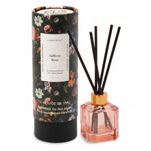 Load image into Gallery viewer, The Botanical Diffuser Set features a floral-patterned box beside a pink glass bottle with a gold collar and four black reeds, highlighting the Botanica Collection’s modern and luxurious scent experience.