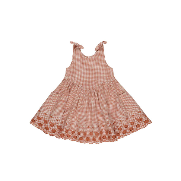The Rylee & Cru Poppy Gingham Dress is a sleeveless, knee-length summer dress for girls, featuring tie straps, a pink and white gingham pattern with poppy print, scalloped hem, and floral details—ideal for warm weather.