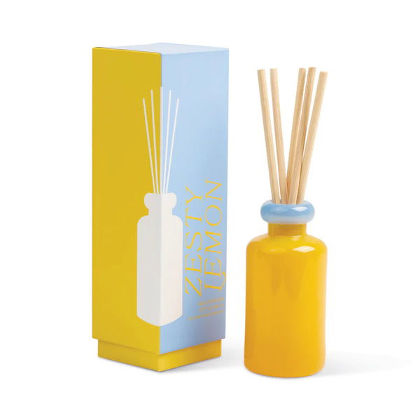 A yellow Stacked Reed Diffuser with wooden reeds and a blue neck sits beside its matching Zesty Lemon box, featuring bold yellow and white text on a blue and yellow background, bringing vibrant fragrance to your space.