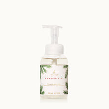 Load image into Gallery viewer, A clear pump bottle of Frasier Fir Home Care Collection foaming hand wash features a white label with pine branch art and gold text. The 305 mL (10.3 fl oz) pale yellow liquid offers a refreshing winter scent.