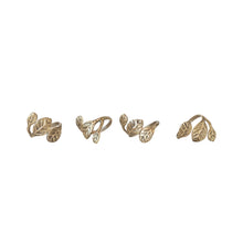 Load image into Gallery viewer, The Brass Leaf Napkin Rings: Set of 4 are shown side by side, each featuring intricate leaf motifs wrapped around the band and photographed on a plain white background.