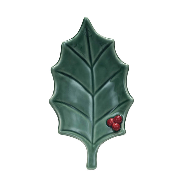 The Holly Leaf Dish is a handcrafted stoneware dish shaped like a green leaf with three red berries in one corner and a unique reactive glaze—perfect for festive or holiday use.