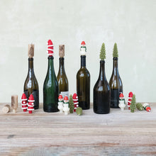 Load image into Gallery viewer, Four unscented candles shaped like Christmas trees, snowmen, and Santas from the Box/4 Shaped Candles set are arranged on a wooden table with festive holiday décor.