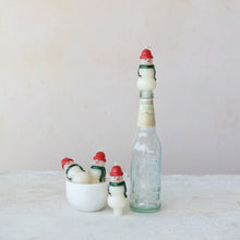 Load image into Gallery viewer, Box/4 Shaped Candles: Three snowman taper candles with red hats sit in a white bowl, while a fourth tops a glass bottle—delightful holiday décor for any space on a light, neutral background.