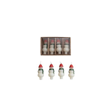 Load image into Gallery viewer, A box of four snowman-shaped, unscented taper candles with red hats and green scarves is displayed in a row—each white candle features painted details, making them perfect for holiday décor. Product: Box/4 Shaped Candles.