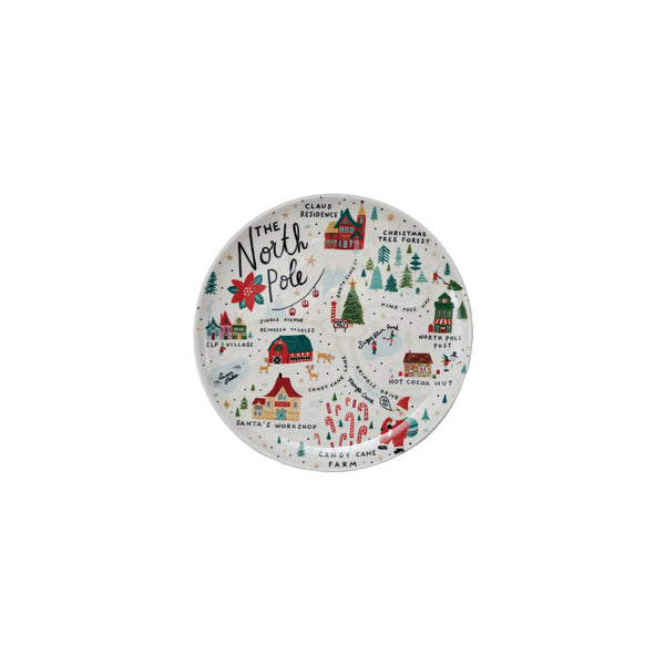 The North Pole Plate is a round stoneware accent featuring a colorful illustrated map with festive sites like Santa's Workshop, Reindeer Stables, and Christmas Tree Forest, plus holiday icons and snow-covered trees.